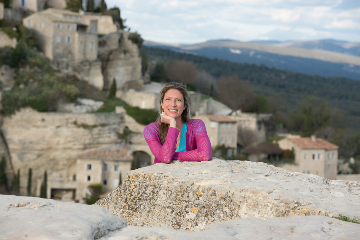 Emily Durand, Chauffeur-Guide von Your Private Provence, posiert vor dem Bergdorf Gordes, einem Symbol des provenzalischen Erbes