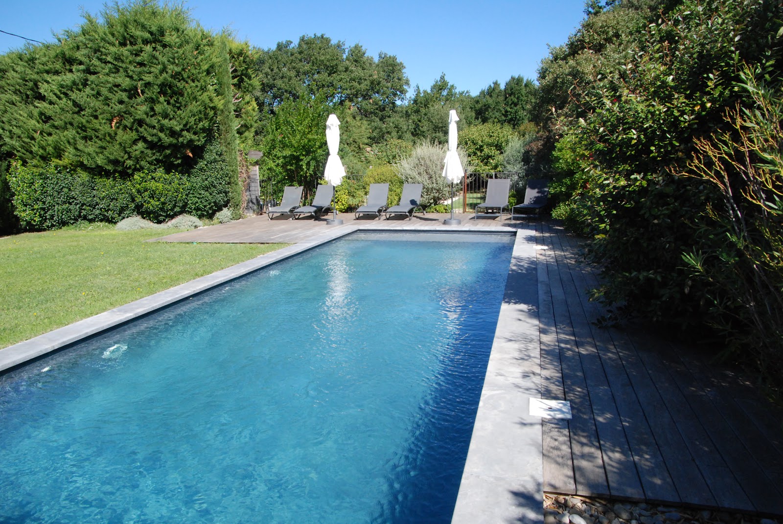 Außenpool der Maison Magnarelles mit Holzterrasse und Liegestühlen