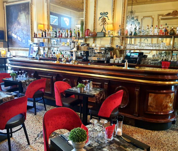 Innenansicht des Café-Brasseries Le Fin de Siècle in Cavaillon mit seiner Holzbar und eleganten Atmosphäre.