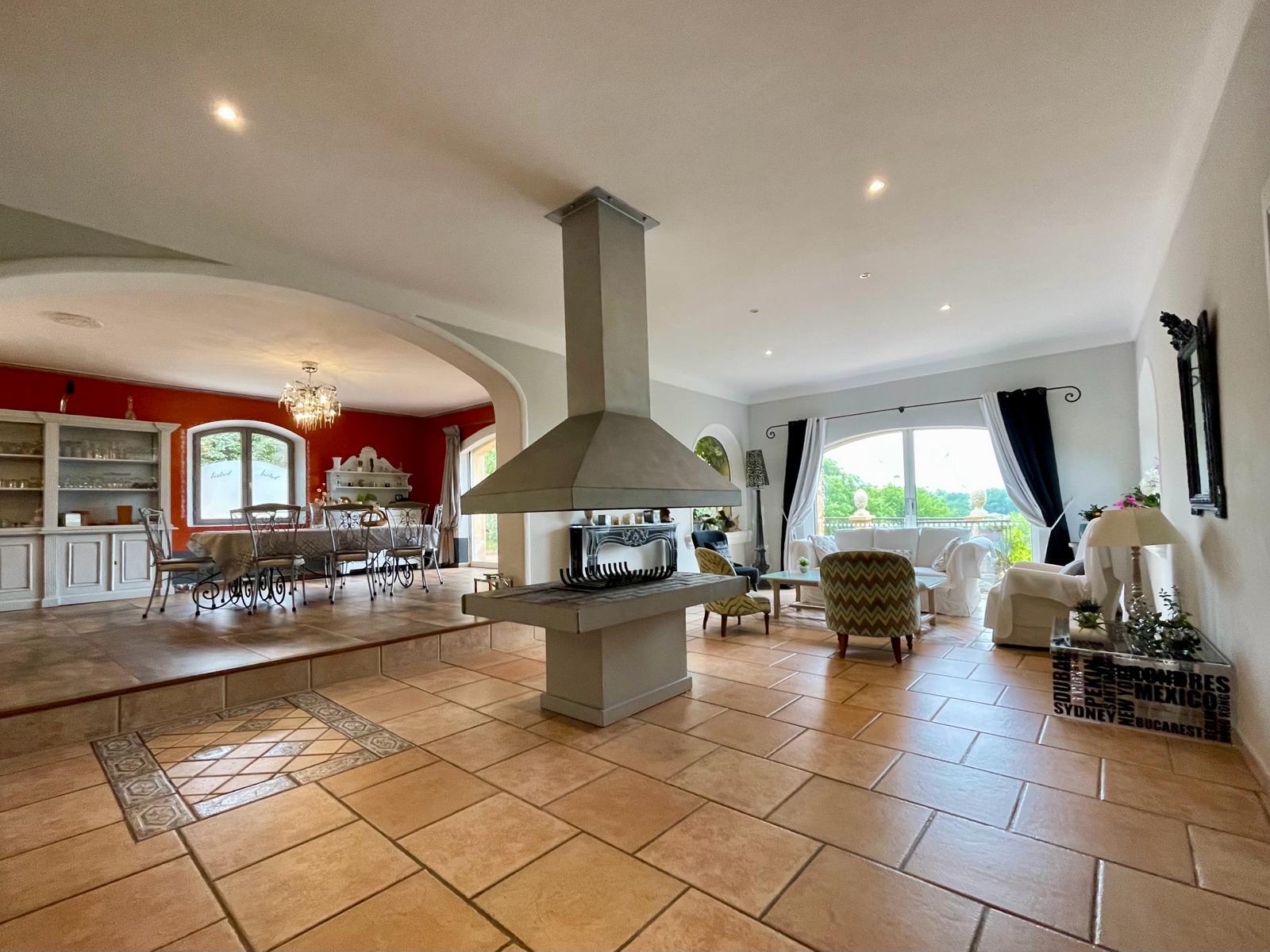 Geräumiges Wohn- und Esszimmer im Domaine Les Félibrés mit raffinierter Dekoration und zentralem Kamin.