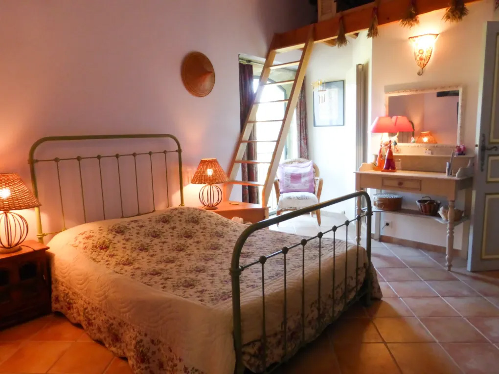 Chambre Lavande auf dem Domaine du Coffre mit Bett aus Schmiedeeisen, Mezzanin und sanften Farbtönen