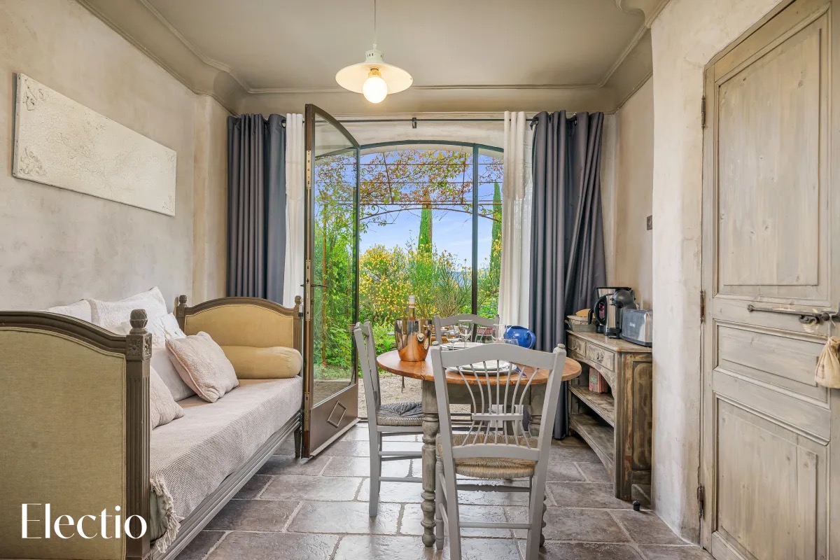 Wohnzimmer der Loggia 4 Genêt mit Tagesbett, Esstisch und Blick auf den Garten von der Terrasse