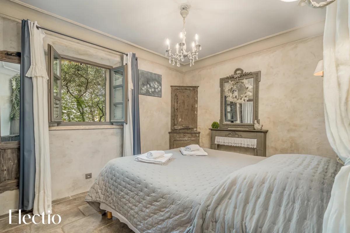 Elegantes Schlafzimmer in der Résidence Les Petitons mit Doppelbett, provenzalischem Dekor und Gartenblick