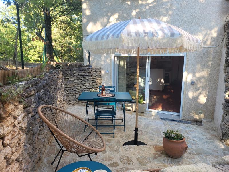 Terrasse des Ferienhauses Le Sarret in Cabrières d’Avignon mit Esstisch und Natursteinmauern