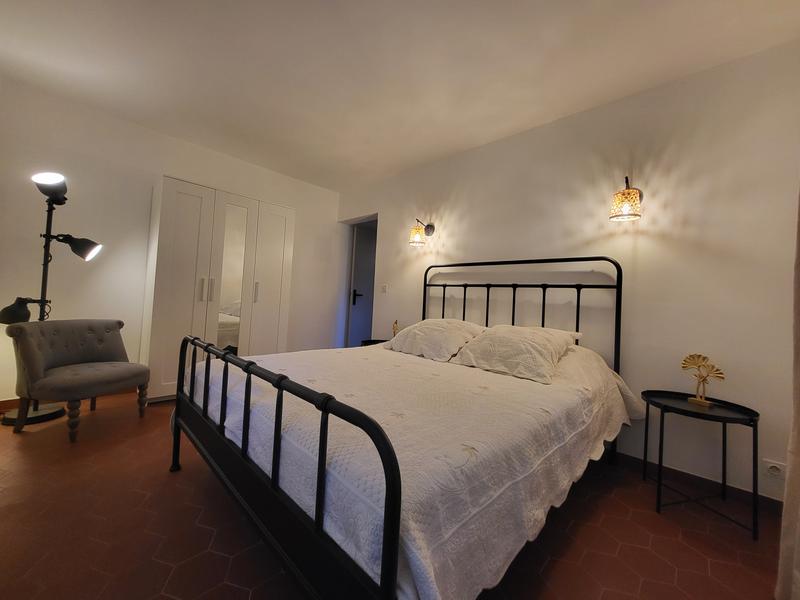Schlafzimmer des Ferienhauses Le Sarret in Cabrières d’Avignon mit Doppelbett und schlichter Einrichtung