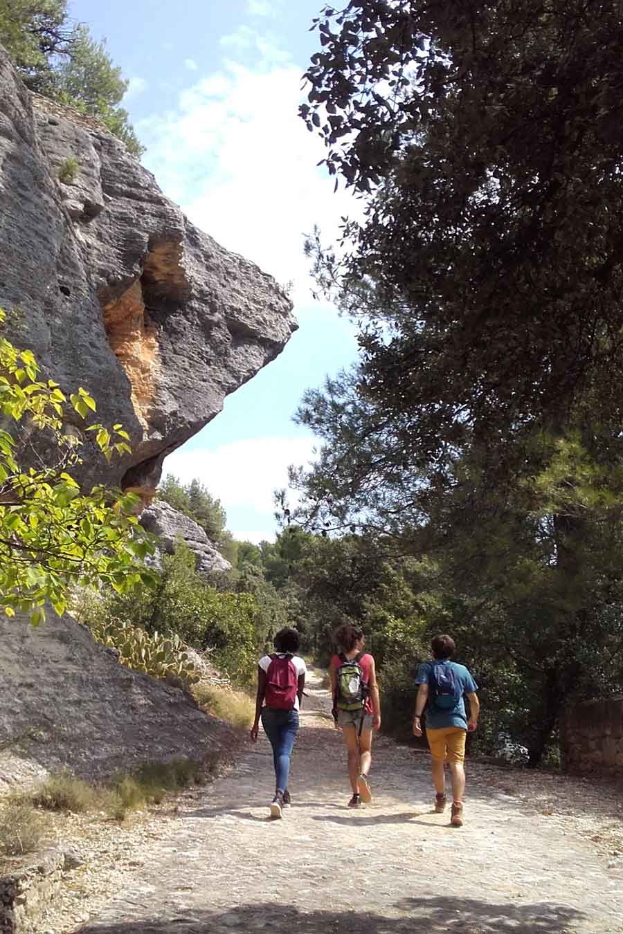 Wanderung in Beaumettes, Wanderer auf einem von Felsen gesäumten Weg