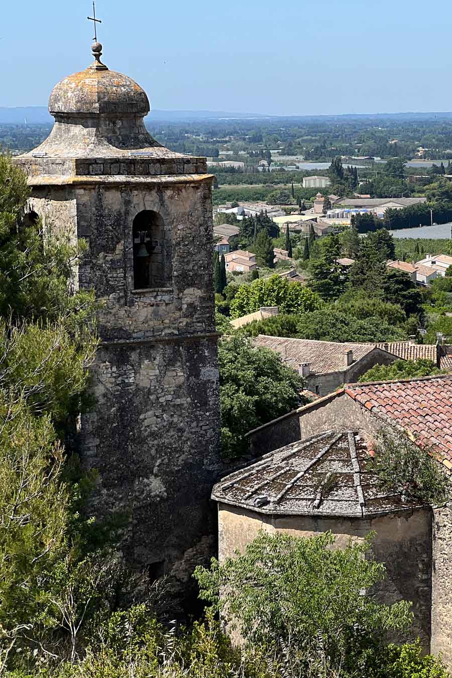 Blick auf den Kirchturm und die Dächer des alten Dorfes Lagnes mit der Ebene im Hintergrund