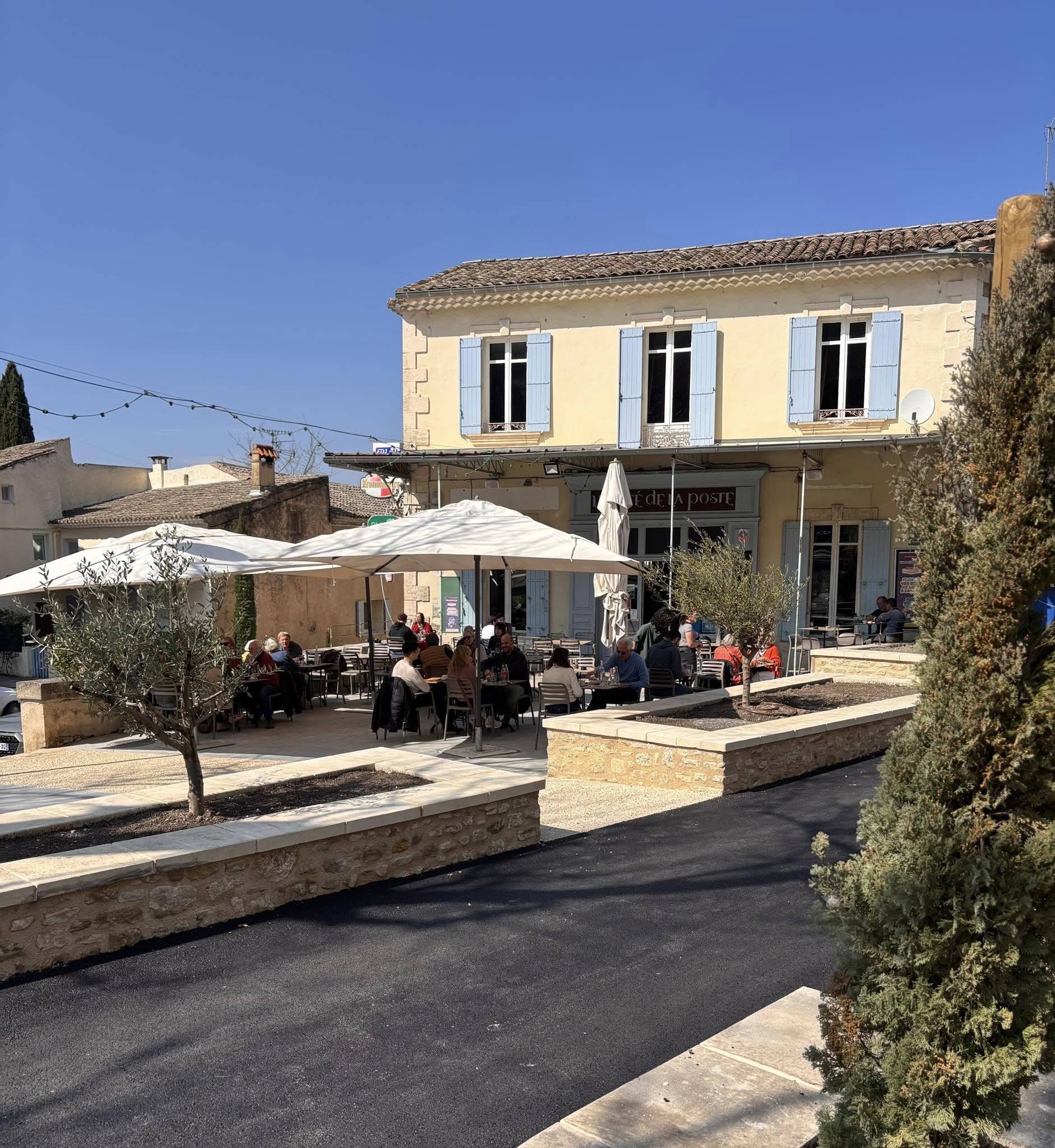 Terrasse des Café de la Poste in Robion, im Herzen des Luberon Sonnige Terrasse des Café de la Poste in Robion im Luberon