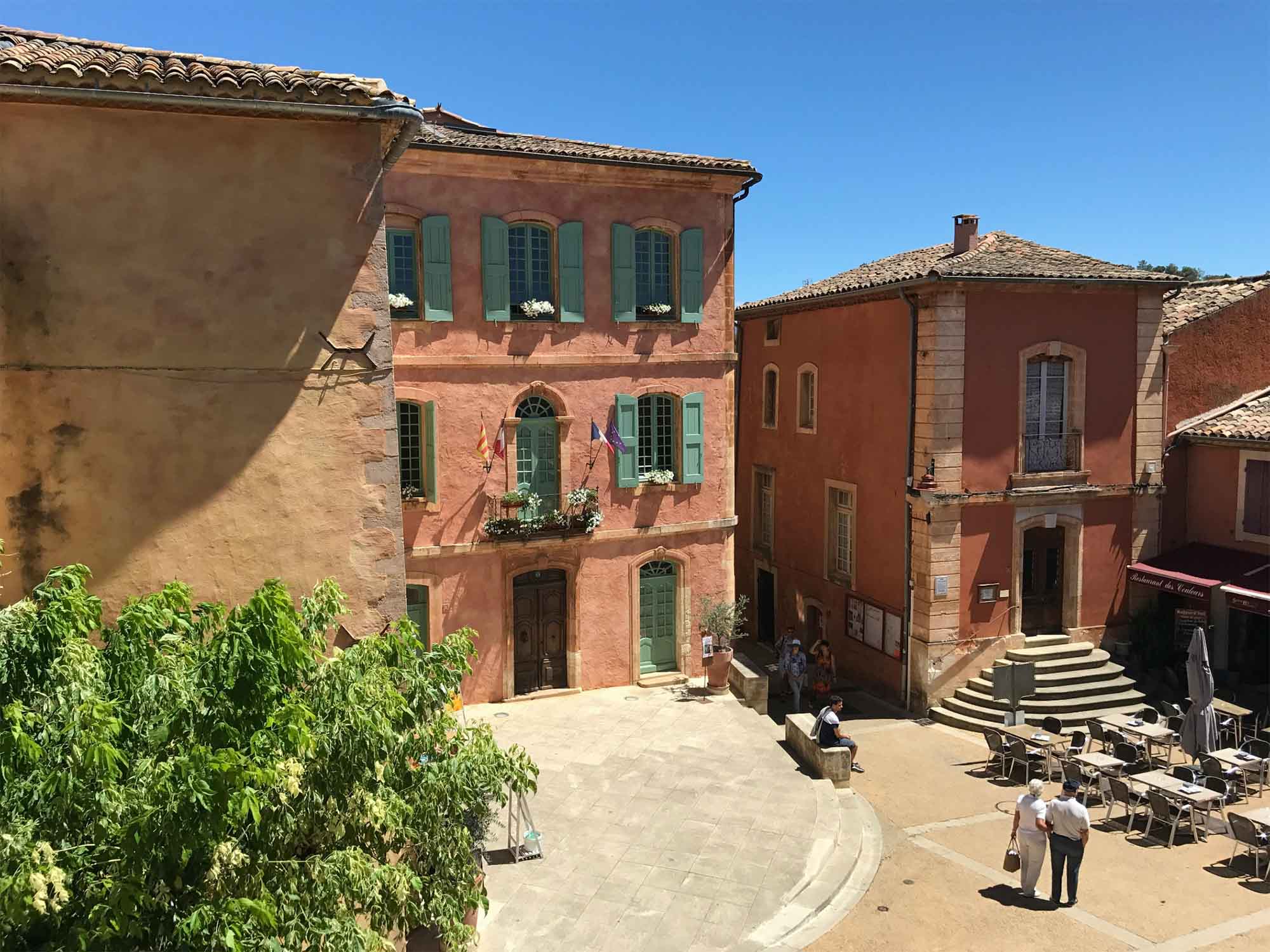 Place de l’Abbé-Avon in Roussillon im Luberon mit ockerfarbenen Fassaden und kleinem Dorfplatz