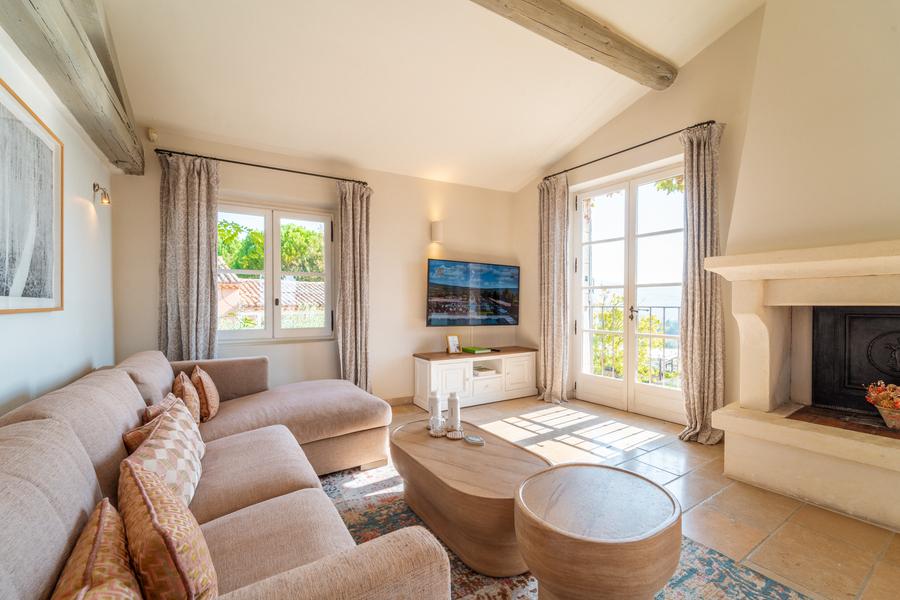 Helles Wohnzimmer einer Suite in der Coquillade Provence mit Kamin und Blick nach draußen