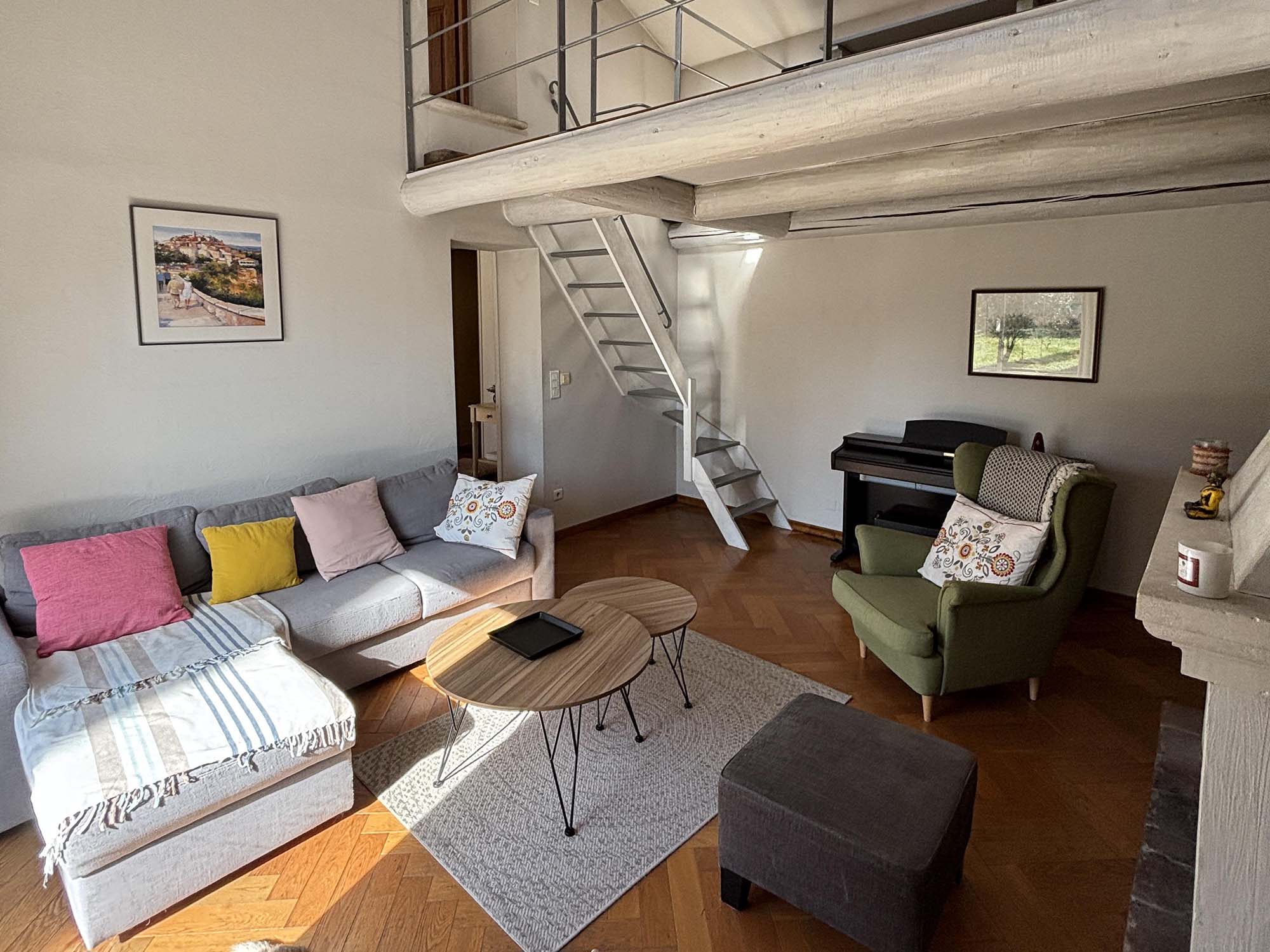 Helles Wohnzimmer des provenzalischen Mas in Cavaillon mit Mezzanin, Sofa und Klavier