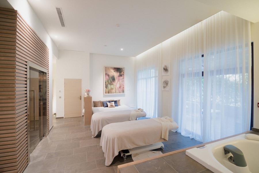 Behandlungsraum im Spa Coquillade Provence mit Massageliegen und natürlichem Licht