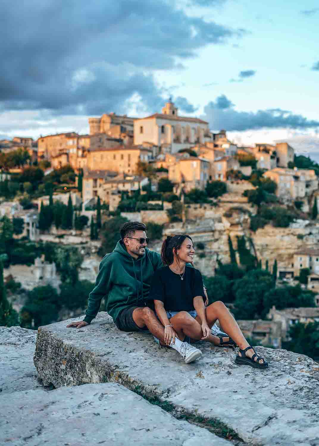 Paar mit Blick auf das hochgelegene Dorf Gordes im Luberon