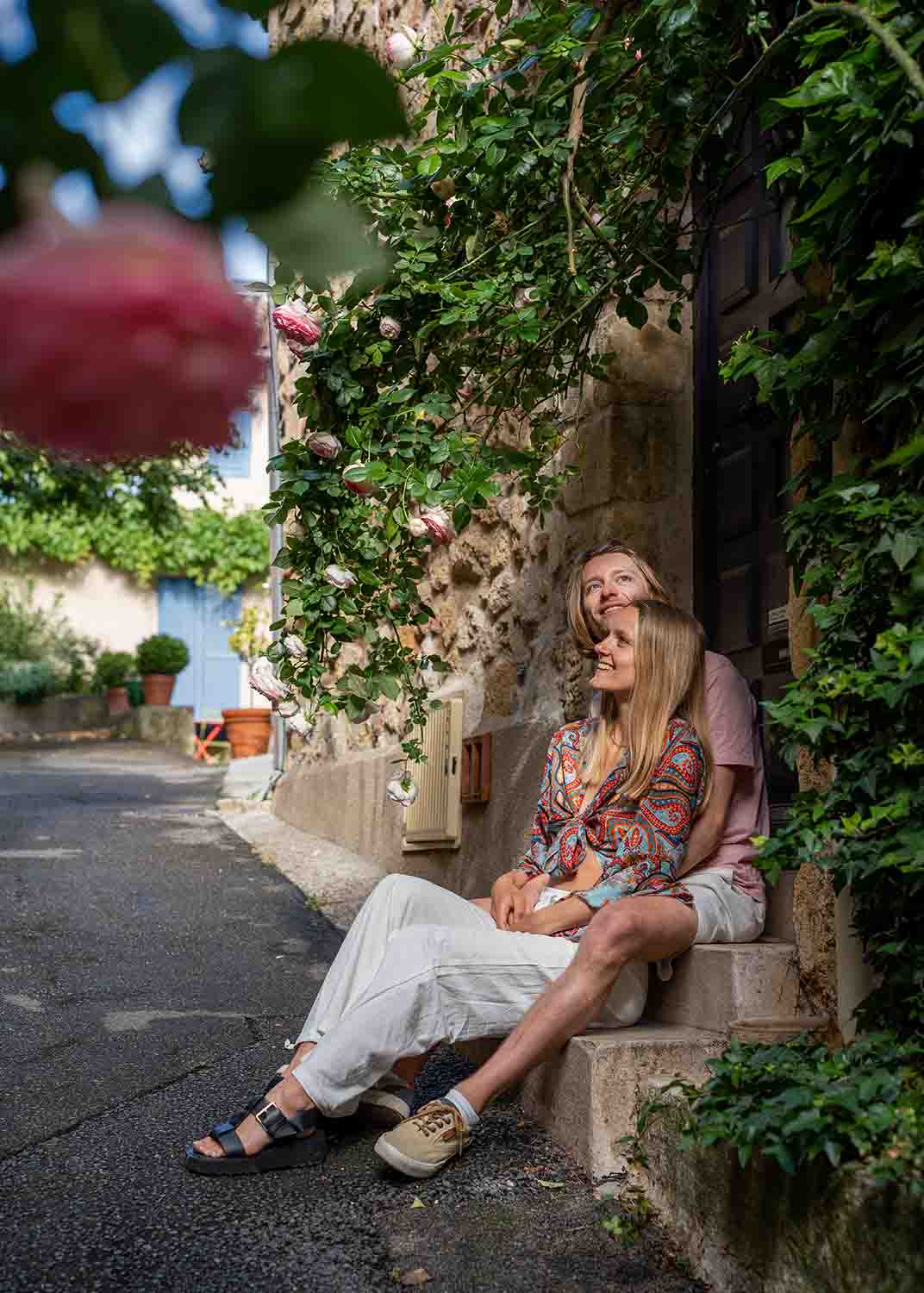 Paar in einer blumengeschmückten Gasse in Lourmarin, einem romantischen Dorf im Luberon