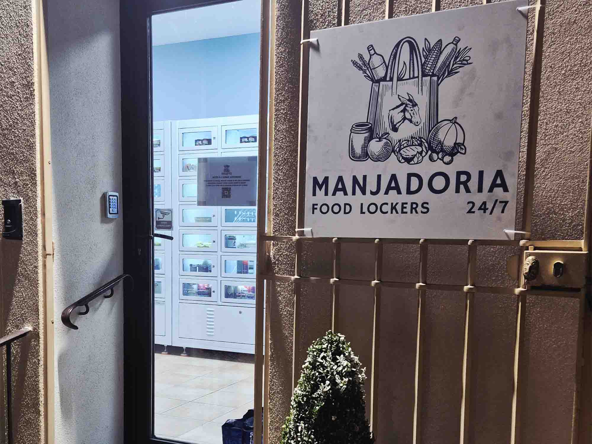 Eingang von Manjadoria mit 24/7 Food-Lockers-Schild und Selbstbedienungs-Lebensmittel-Schließfächern