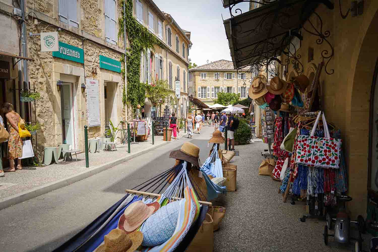Belebte Straße in Lourmarin mit Geschäften und Dorfatmosphäre