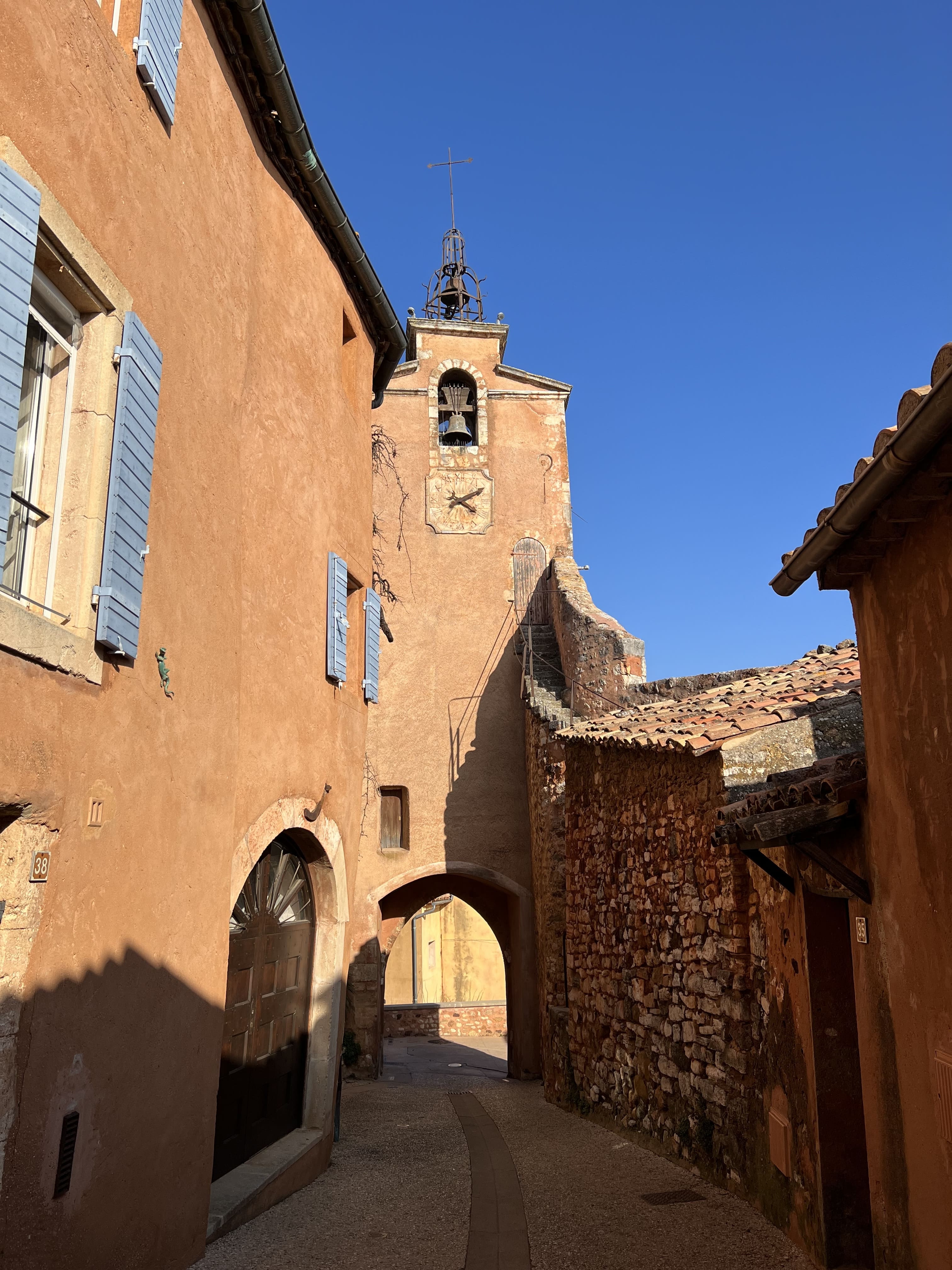 Glockenturm von Roussillon im Luberon mit ockerfarbener Turm und Uhr im Herzen des Dorfes