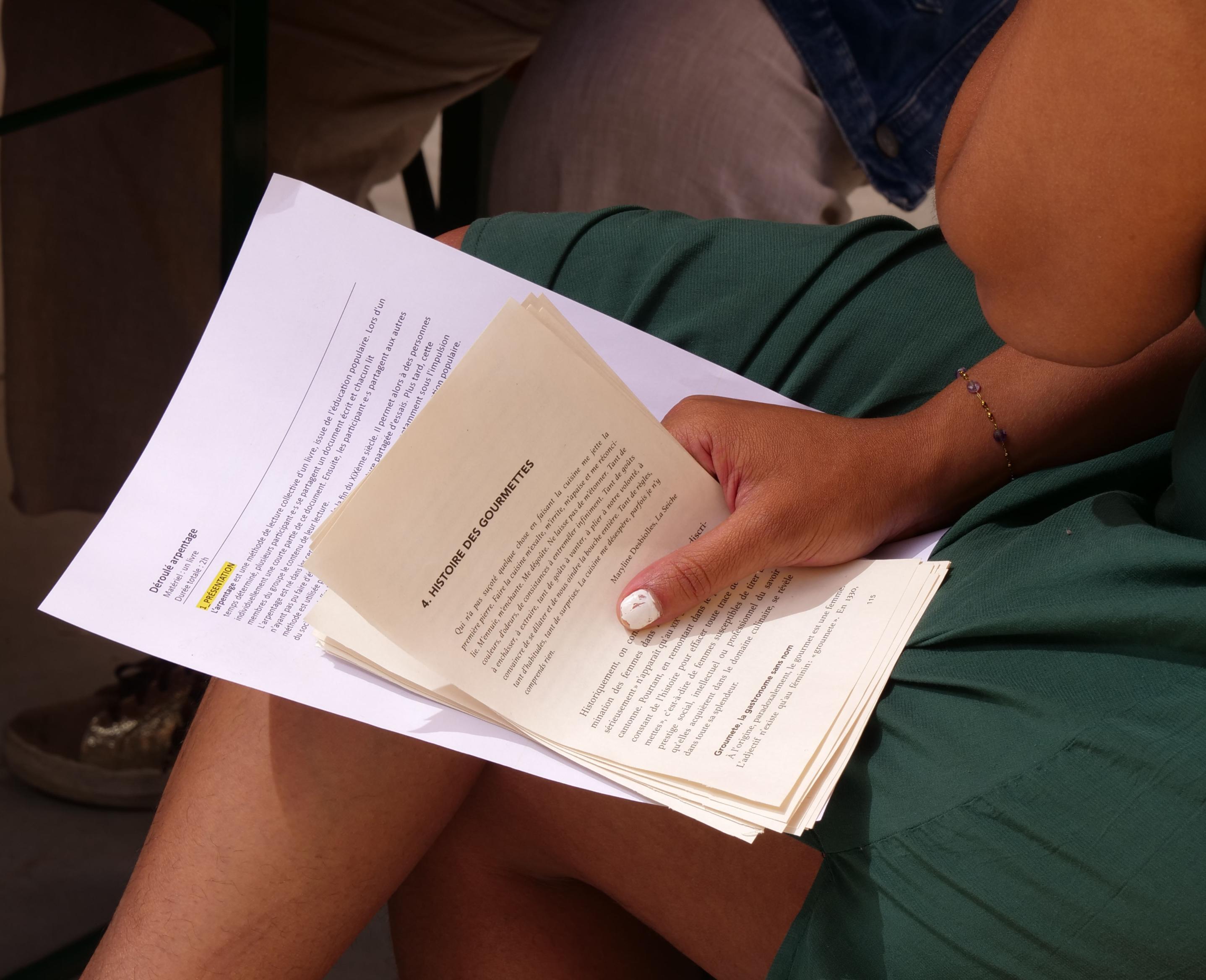 Teilnehmende blättert in einem Buch während eines kollektiven und partizipativen Lese-Workshops zum Thema Ernährung beim Festival Confit!