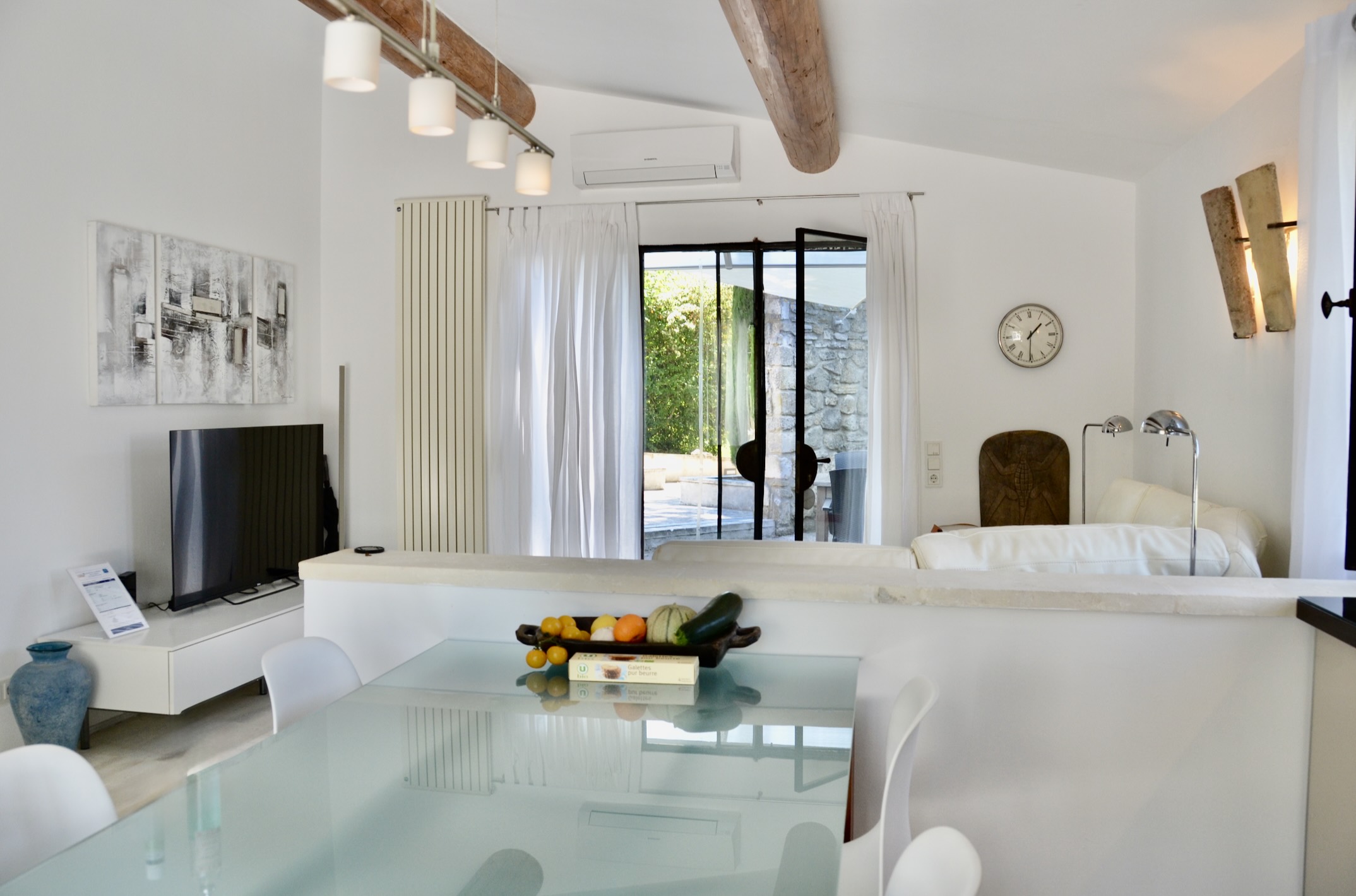 Helles Wohnzimmer mit modernem Sofa und voll ausgestatteter offener Küche im Haus Les Oliviers in Oppède im Luberon