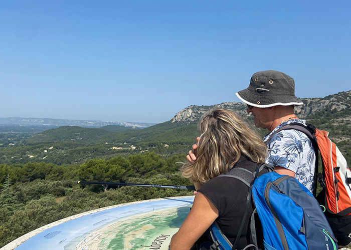 Wanderer beim Blick auf die Landschaften des Petit Luberon oberhalb von Mérindol