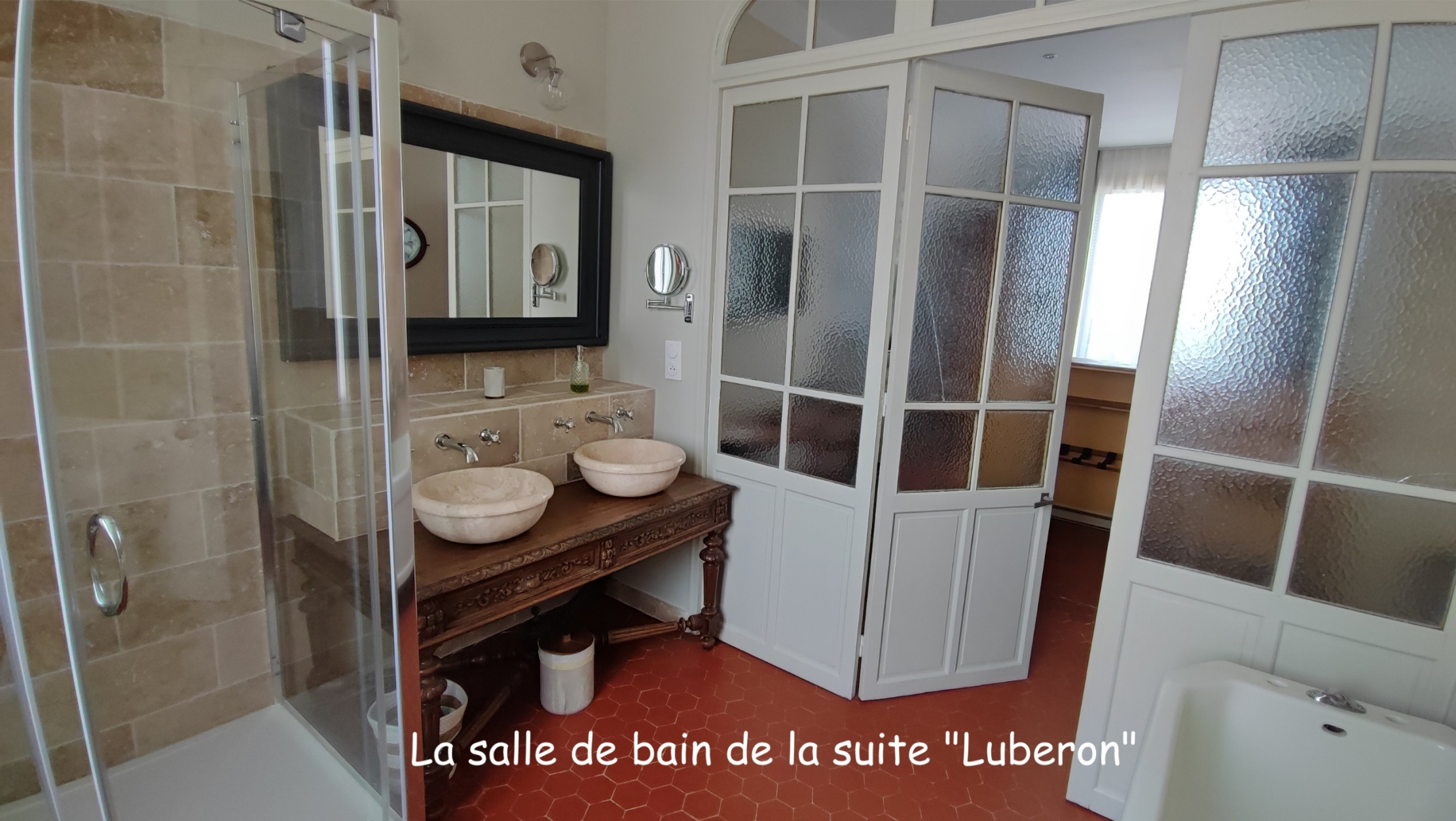 Badezimmer der Suite Luberon mit Badewanne, Dusche und Doppelwaschbecken