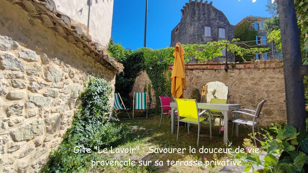 Private Terrasse des Ferienhauses Le Lavoir mit Gartenmöbeln und Sonnenschirm