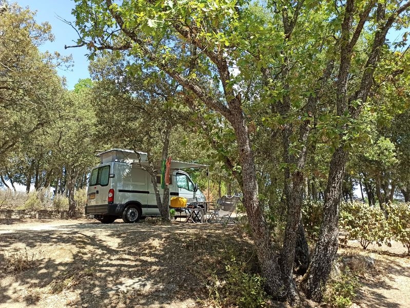 Ausgebauter Van unter den Bäumen auf einem Stellplatz des Camping Le Moulin à Vent