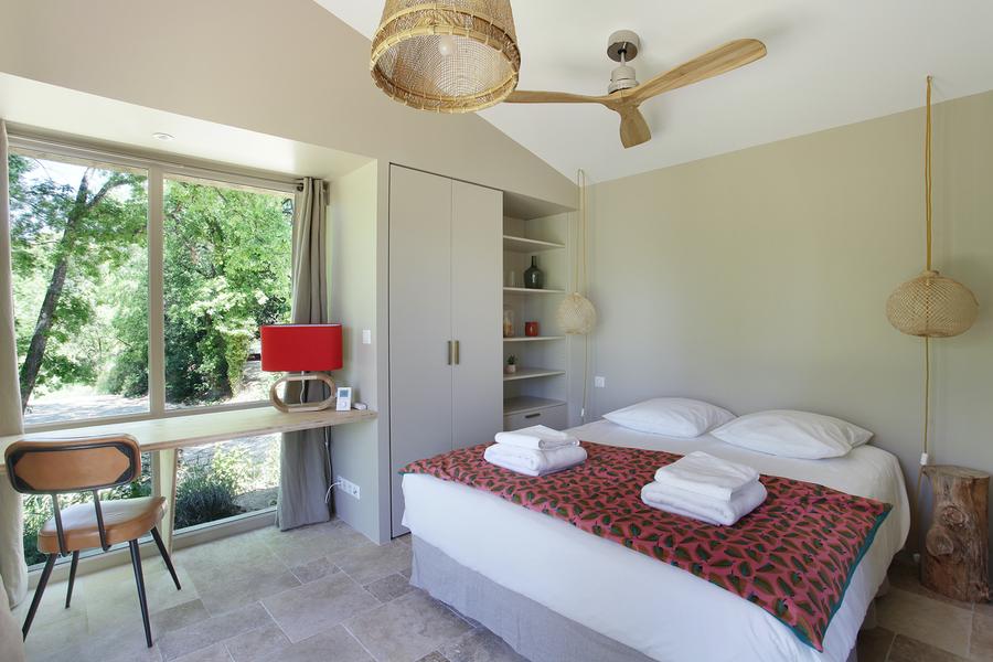 Helles Schlafzimmer des Gîte Sénécio im Domaine Les Petites Vaines, mit Panoramablick auf die Natur und einer schlichten, eleganten Einrichtung.