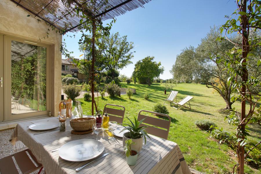 Private Terrasse des Gîte Senecio im Domaine Les Petites Vaines mit Blick auf den grünen Garten und Liegestühlen