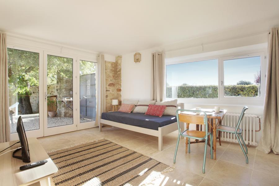 Helles Wohnzimmer des Gîte Salvia im Domaine Les Petites Vaines, mit Essbereich und großen Öffnungen zur Außenwelt