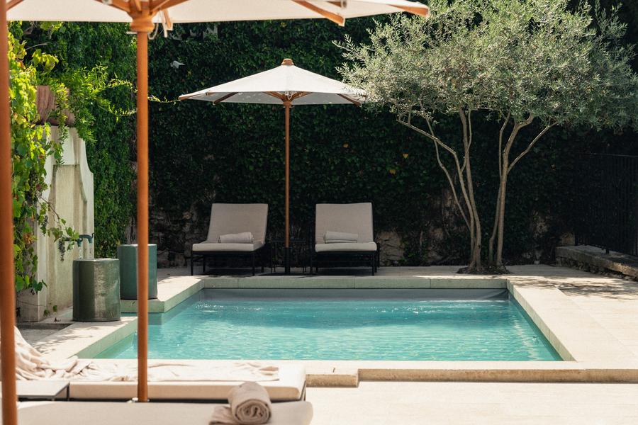 Außenpool im Le Moulin in Lourmarin mit Liegestühlen und intimem Garten