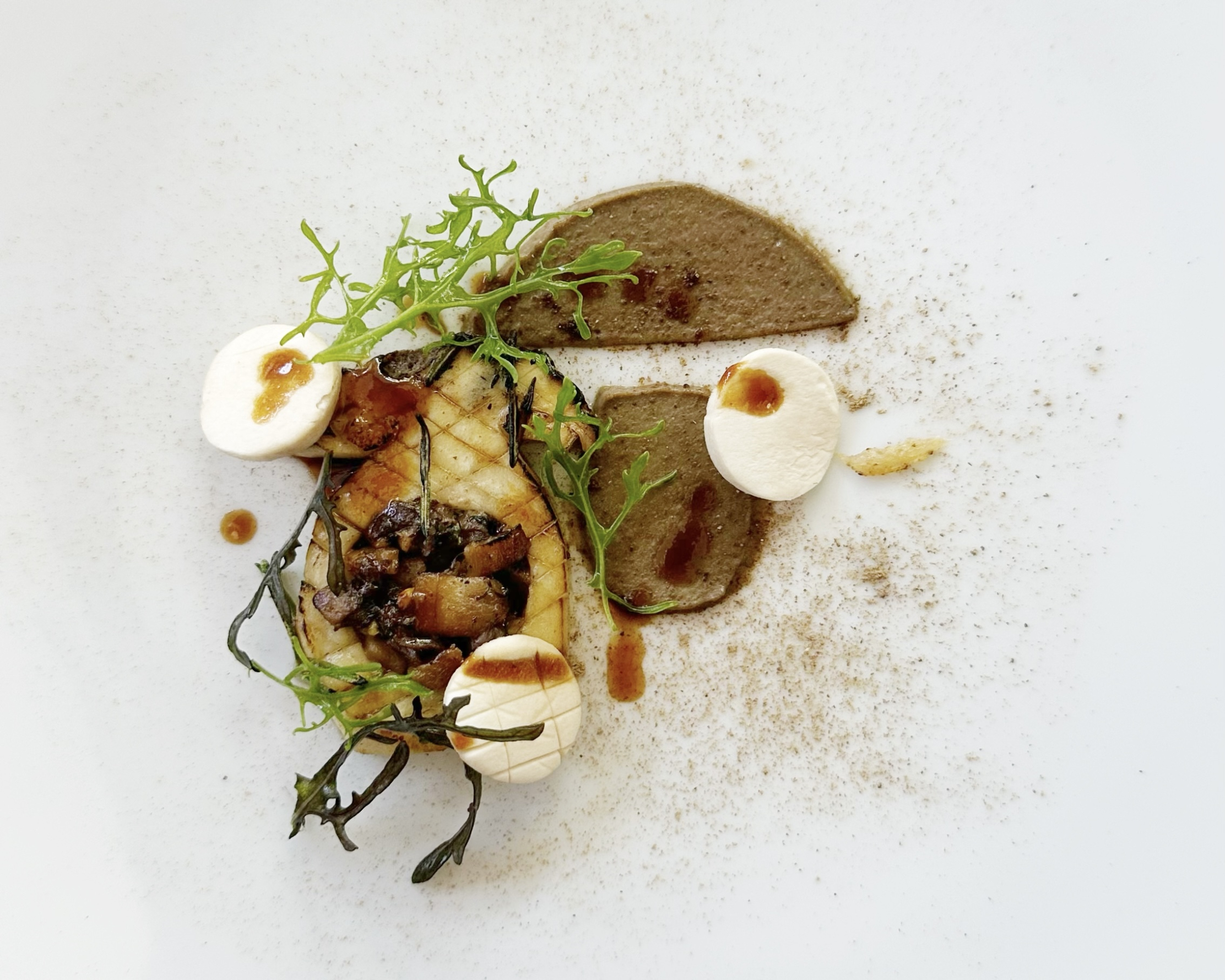 Aufwendige kulinarische Kreation des Restaurants L'Olivier, die Pilze, Püree und frische Kräuter in einer künstlerischen Präsentation kombiniert.