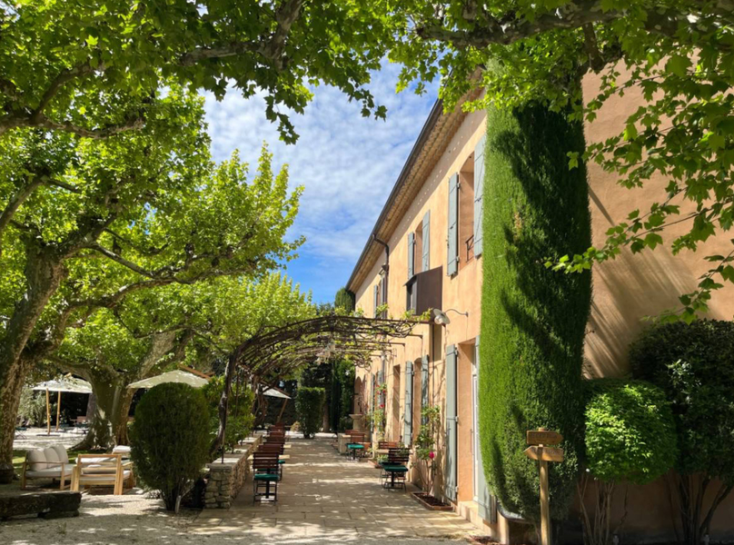 Fassade des Mas des Grès in Lagnes und schattige Terrasse unter jahrhundertealten Platanen